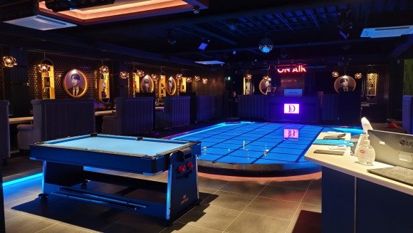 레드와 그린 컬러로 포인트를 준 라운드 부스와 흑경 부스가 배치된 공간