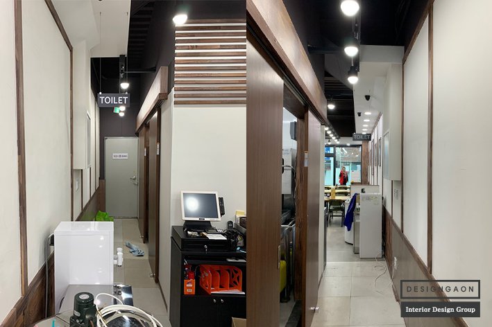 완성된 식당 인테리어의 화이트·원목·그래픽 요소 조화