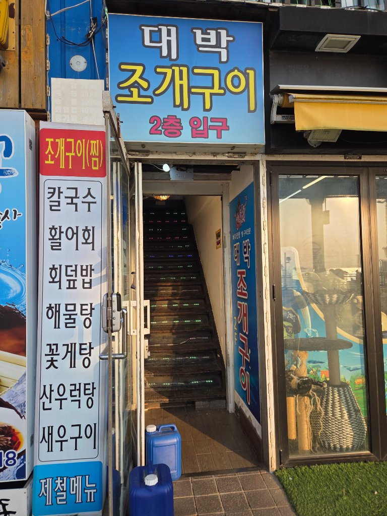 그릴 위에서 버터와 함께 구워지는 신선한 가리비와 조개류